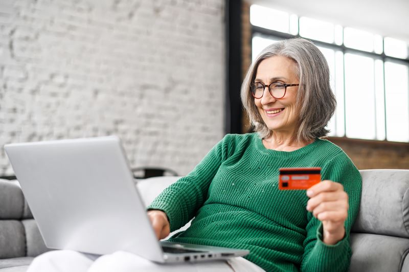 Woman using credit card while on computer